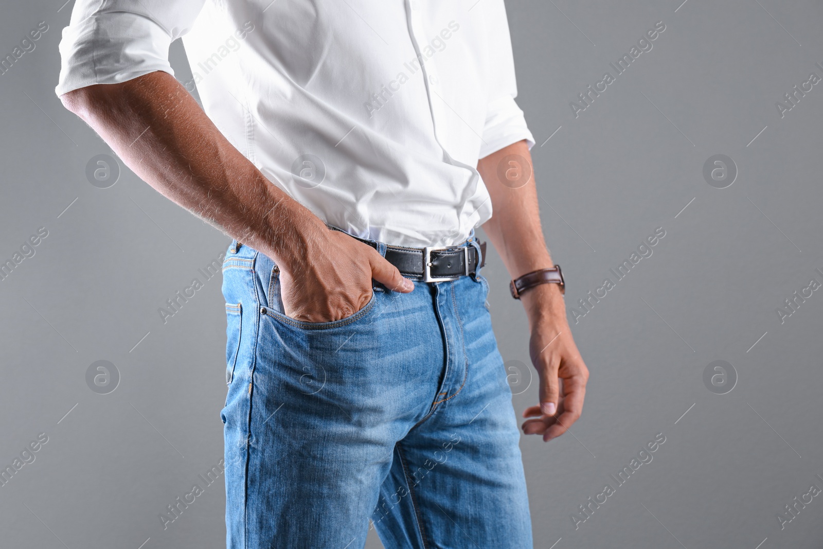 Photo of Man in stylish blue jeans on grey background