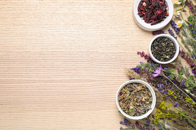 Photo of Flat lay composition with healing herbs on wooden table. Space for text