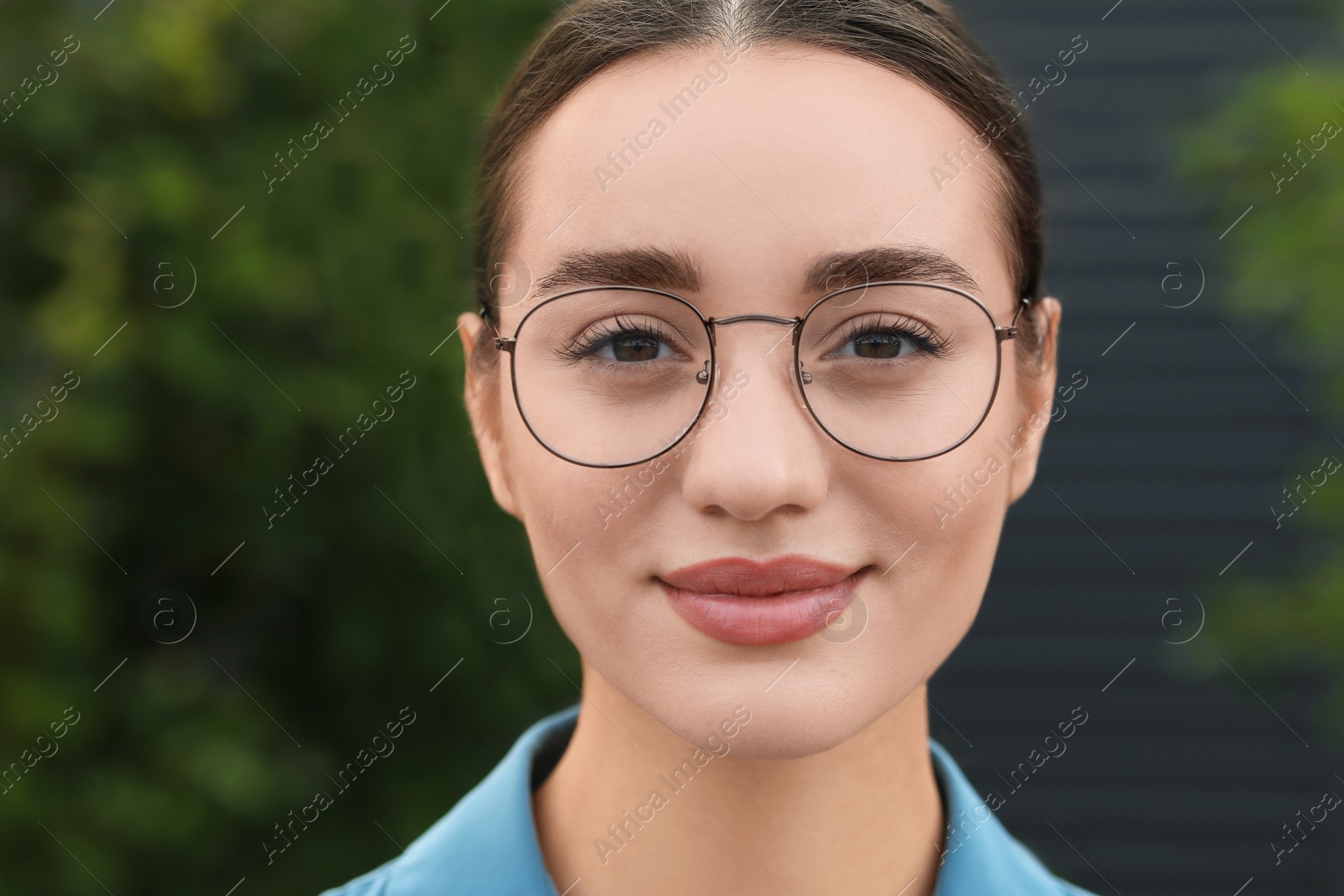 Photo of Portrait of beautiful woman in glasses on blurred background. Attractive lady looking into camera