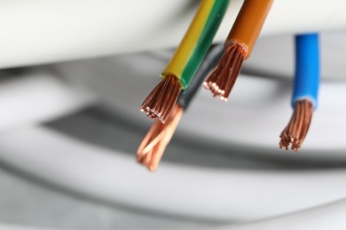 Photo of Colorful electrical wires on blurred background, closeup