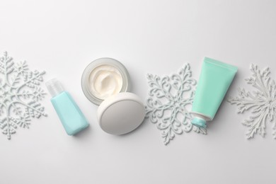 Photo of Winter skin care. Flat lay composition with hand cream and cosmetic products on white background