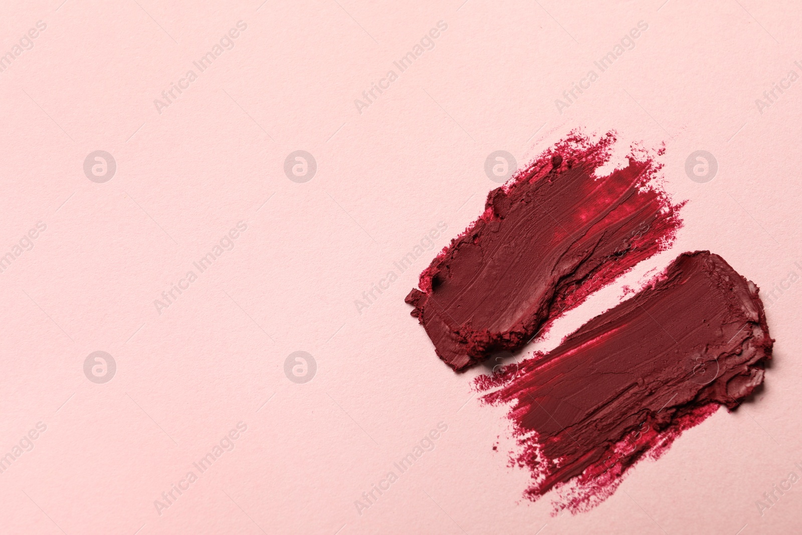 Photo of Smears of bright lipstick on light background, top view. Space for text