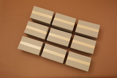 Photo of Many cardboard boxes on brown background, flat lay