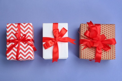 Beautifully decorated gift boxes on color background, top view