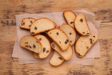 Photo of Sweet hard chuck crackers with raisins on wooden table, flat lay