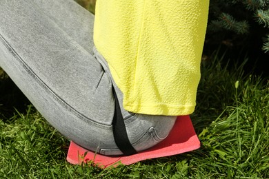 Photo of Woman sitting on foam tourist mat outdoors, closeup