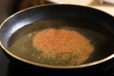 Photo of Frying pan with used cooking oil on stove, closeup