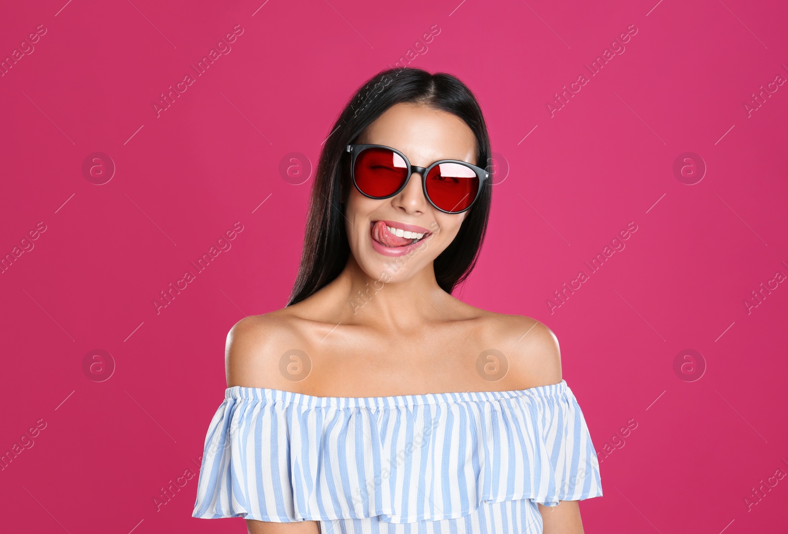 Photo of Beautiful woman wearing sunglasses on pink background
