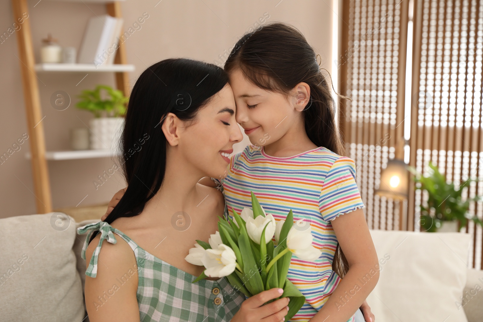 Photo of Little daughter congratulating her mom at home. Happy Mother's Day