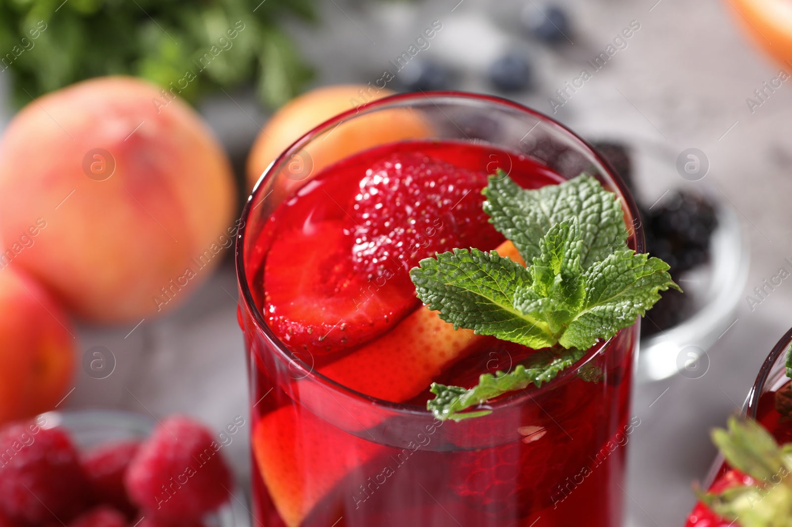 Photo of Glass of delicious refreshing sangria on blurred background, closeup view