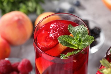 Photo of Glass of delicious refreshing sangria on blurred background, closeup view