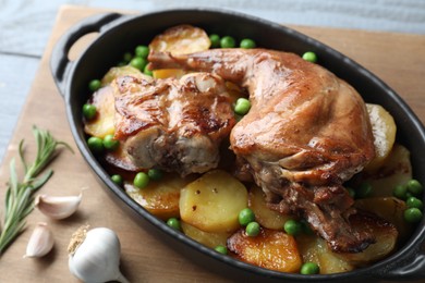 Photo of Tasty cooked rabbit with vegetables in baking dish on table, closeup
