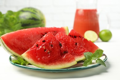 Photo of Plate with slices of juicy watermelon on white wooden table