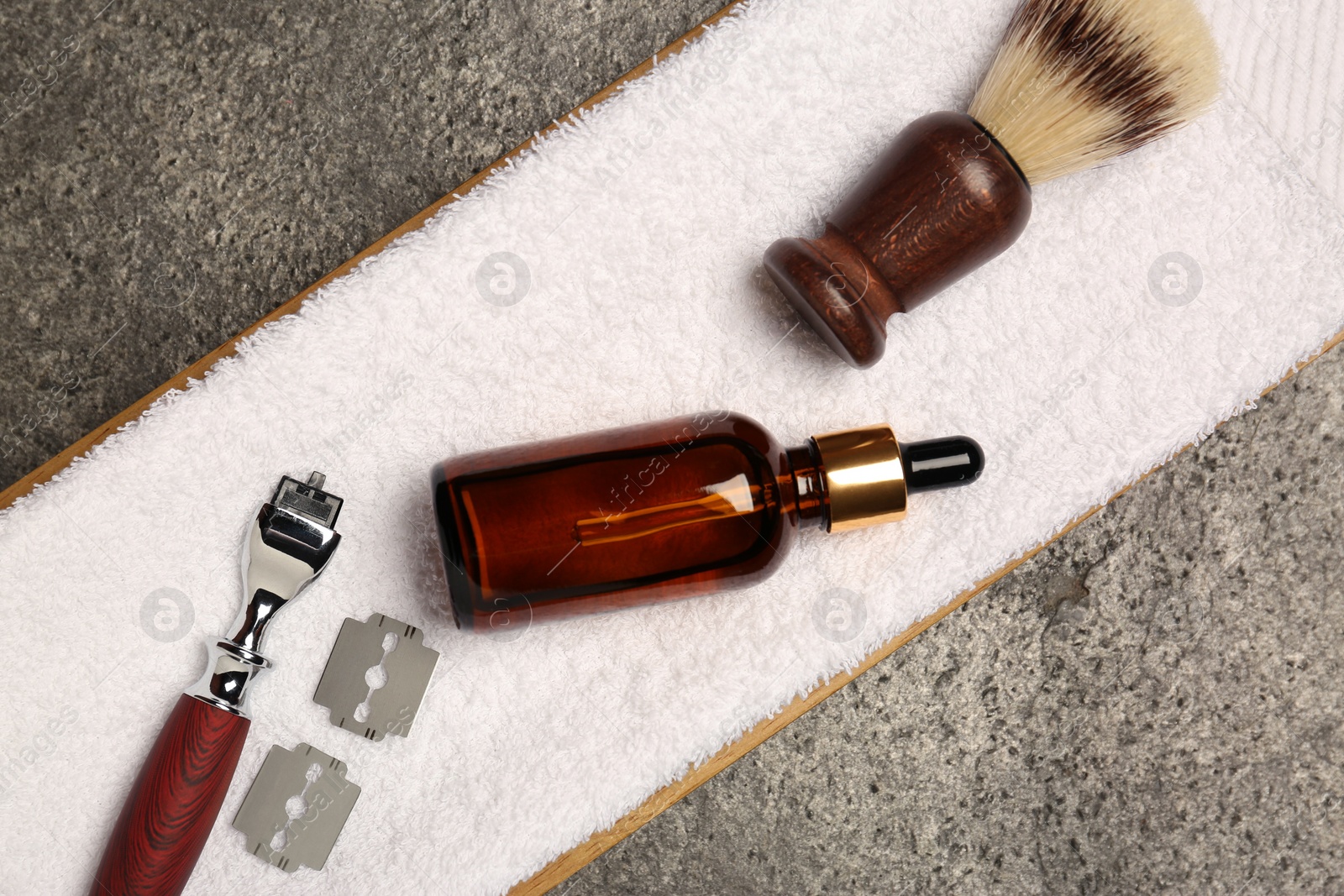 Photo of Tray with shaving accessories for men and towel on grey table, top view