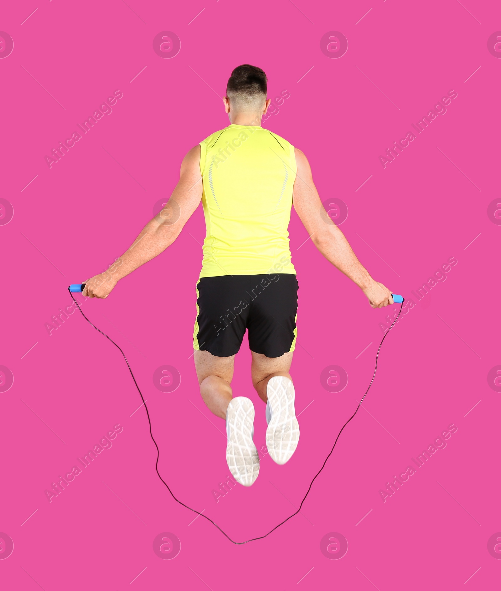 Photo of Sportive man training with jump rope on color background