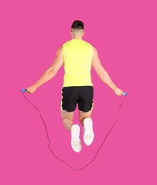Photo of Sportive man training with jump rope on color background