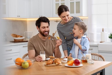 Happy family having breakfast at table in kitchen