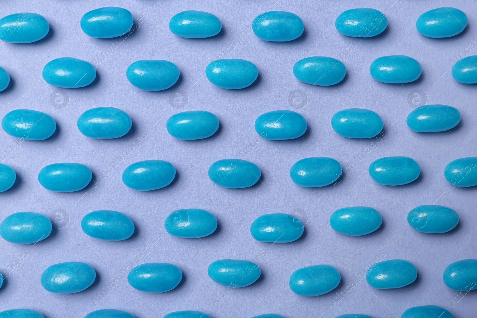 Photo of Many delicious jelly beans on color background, flat lay