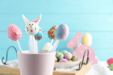 Photo of Different delicious sweet cake pops on light blue background, closeup. Easter holiday