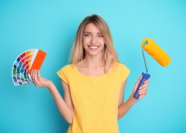 Photo of Young woman with palette and roller on color background