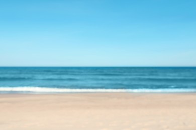 Photo of Blurred view of beautiful sea and sandy beach on sunny day