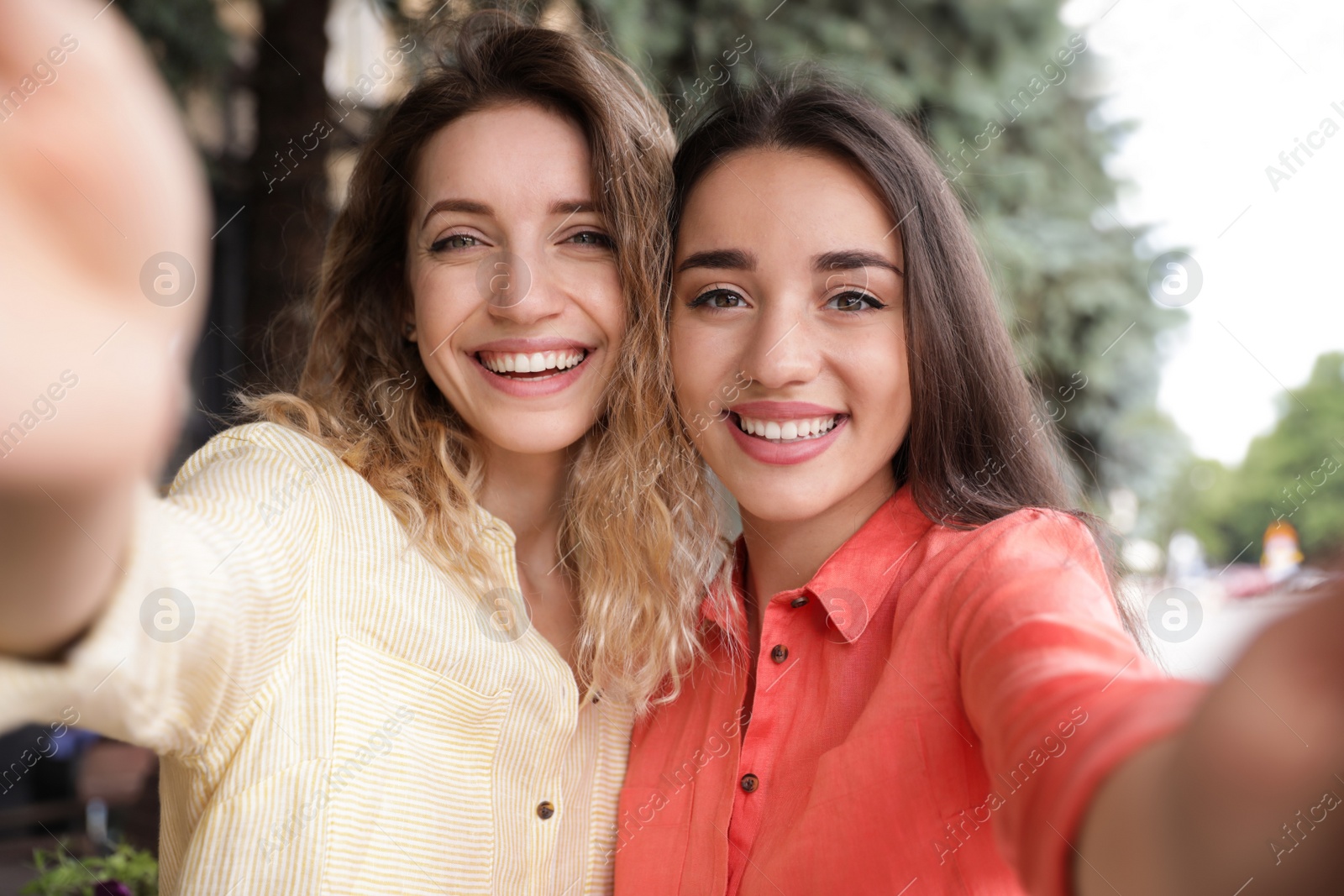 Photo of Beautiful young women taking selfie outdoors on sunny day
