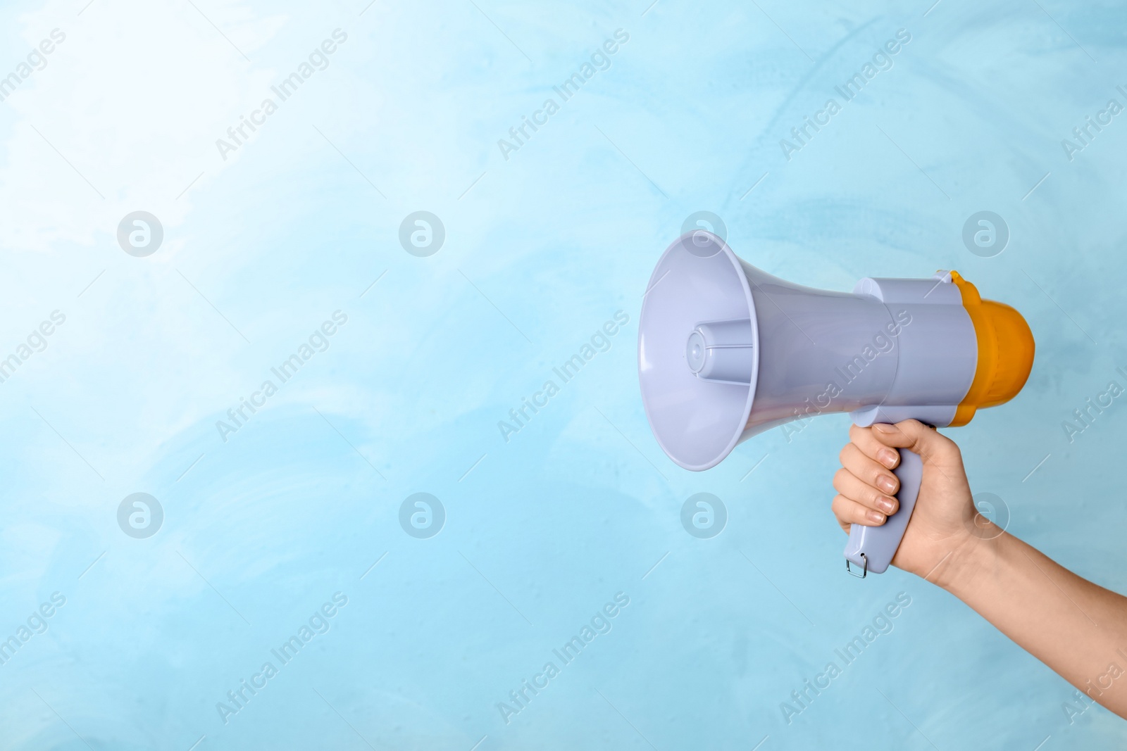 Photo of Woman holding megaphone on color background
