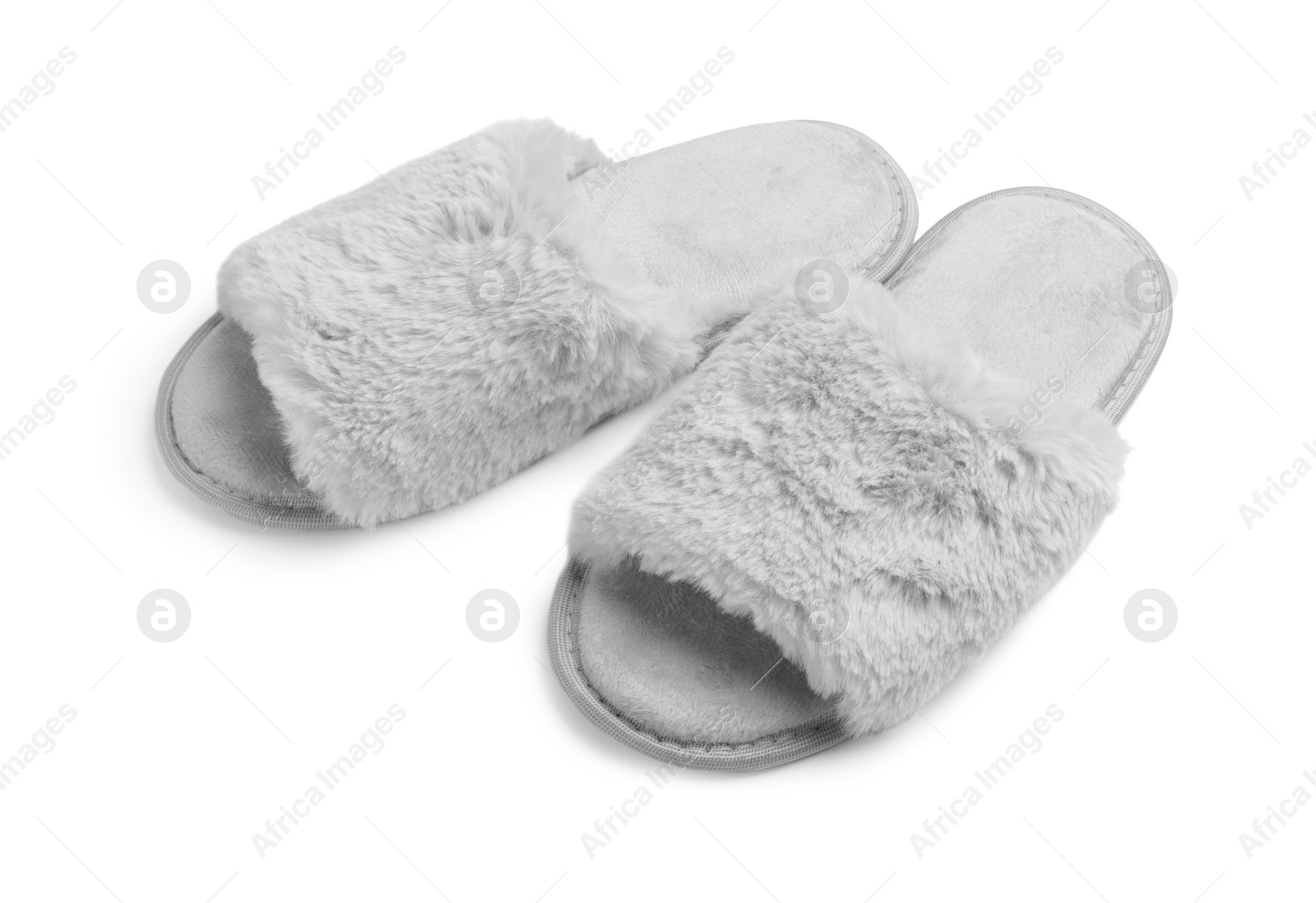 Photo of Pair of soft fluffy slippers on white background