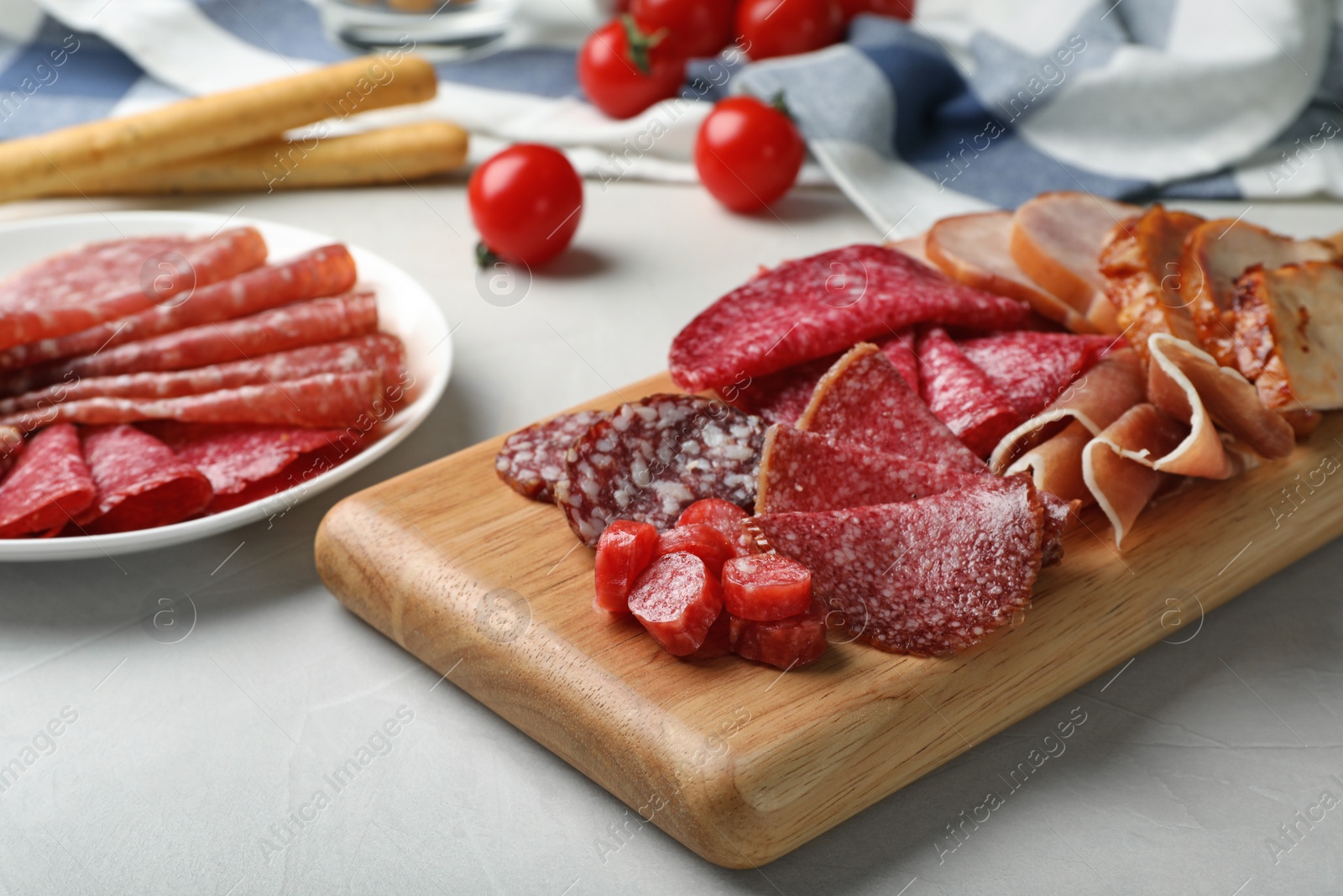 Photo of Cutting board with different sliced meat products served on table