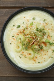 Bowl of delicious celery soup on wooden table, top view