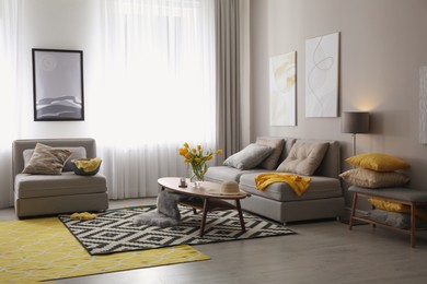 Stylish living room interior with comfortable sofa. Interior design in grey and yellow colors