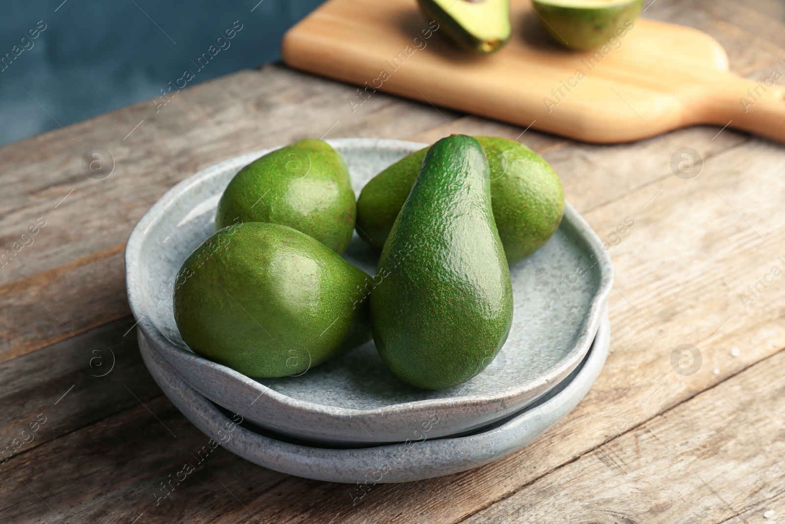 Photo of Plate with ripe avocados on wooden table