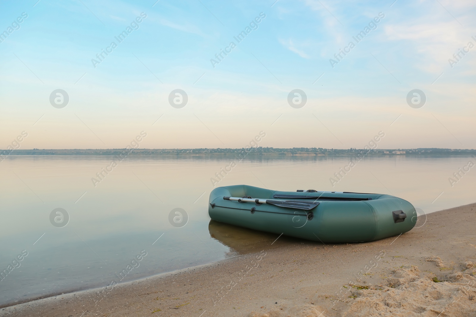 Photo of Inflatable rubber fishing boat on sandy beach near river, space for text