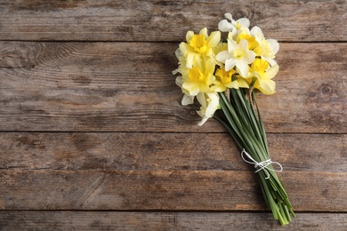 Photo of Bouquet of daffodils on wooden background, top view with space for text. Fresh spring flowers