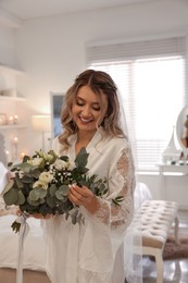 Happy bride with beautiful bouquet at home. Wedding day