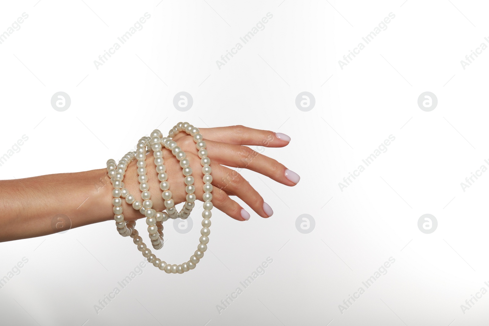 Photo of Young woman with elegant pearl necklace on white background, closeup