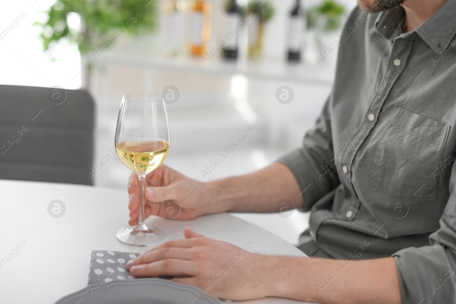 Photo of Young man with glass of wine indoors