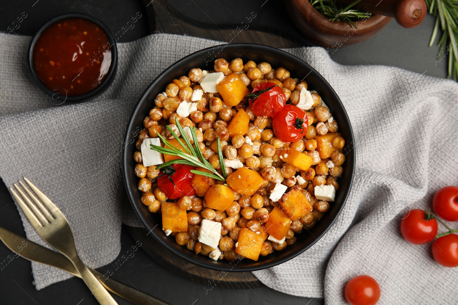 Photo of Delicious fresh chickpea salad served on black table, flat lay