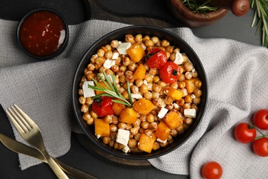 Photo of Delicious fresh chickpea salad served on black table, flat lay