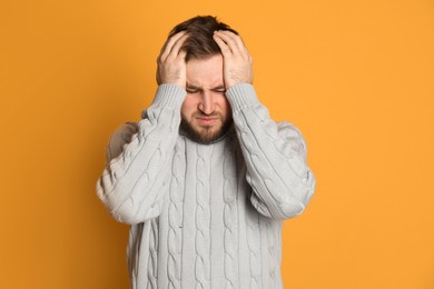 Photo of Man suffering from migraine on yellow background
