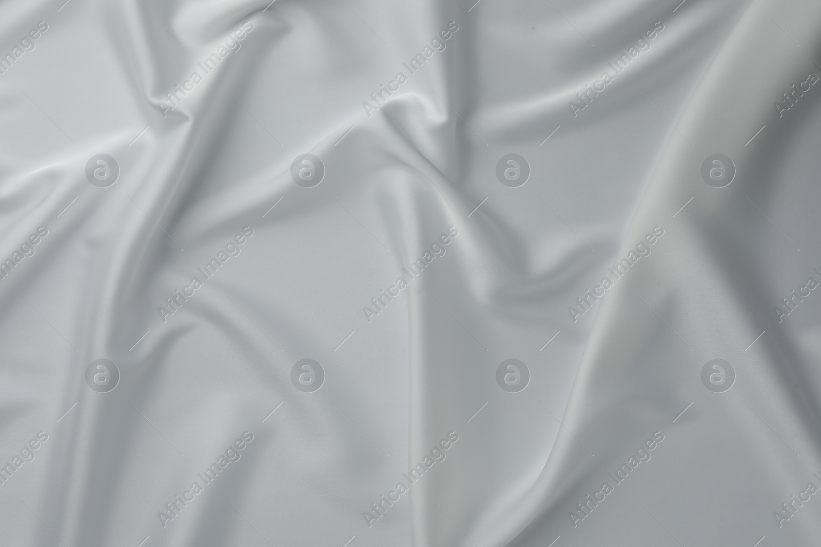 Photo of Texture of crumpled white silk fabric as background, top view