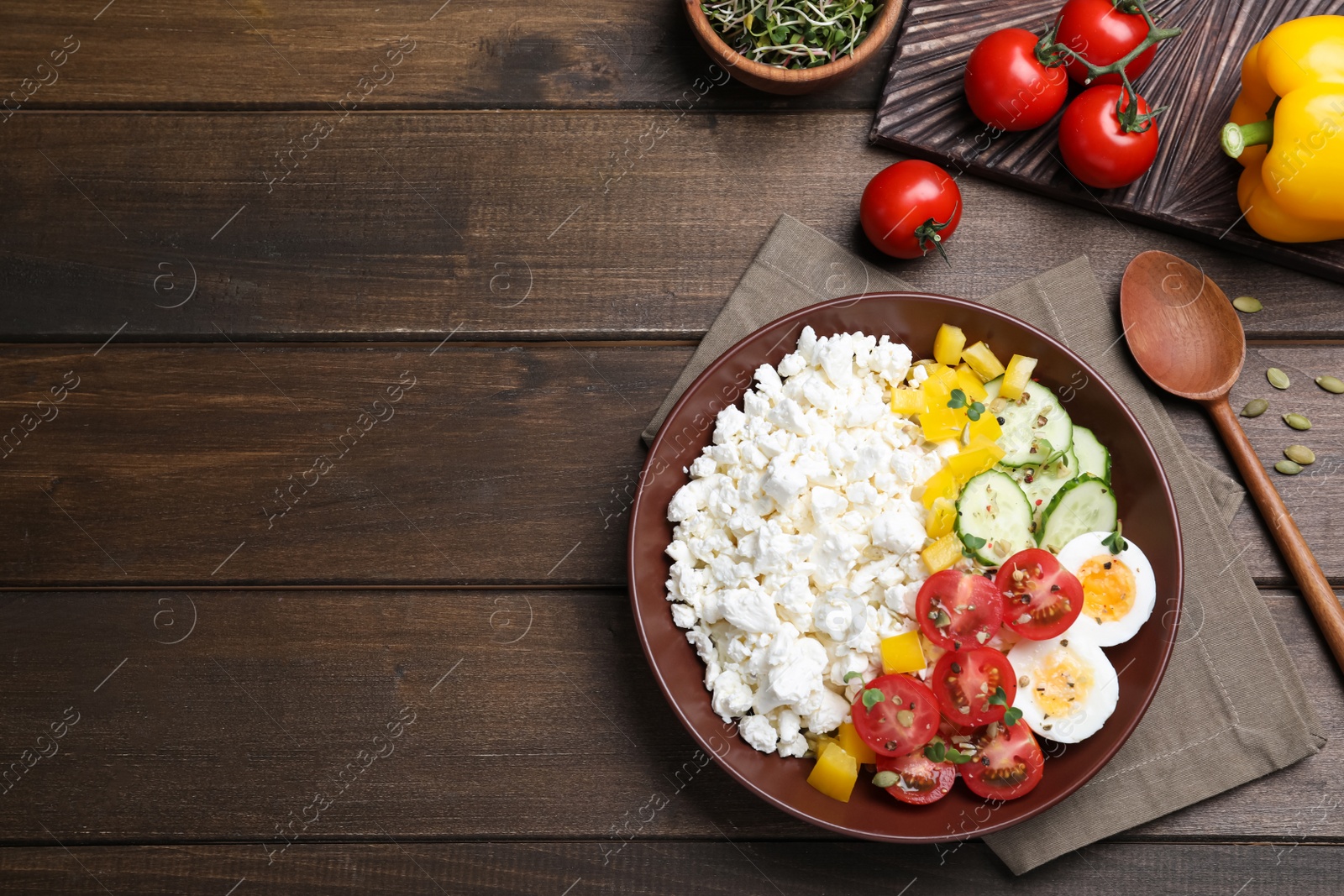 Photo of Delicious cottage cheese with vegetables and boiled egg served on wooden table, flat lay. Space for text