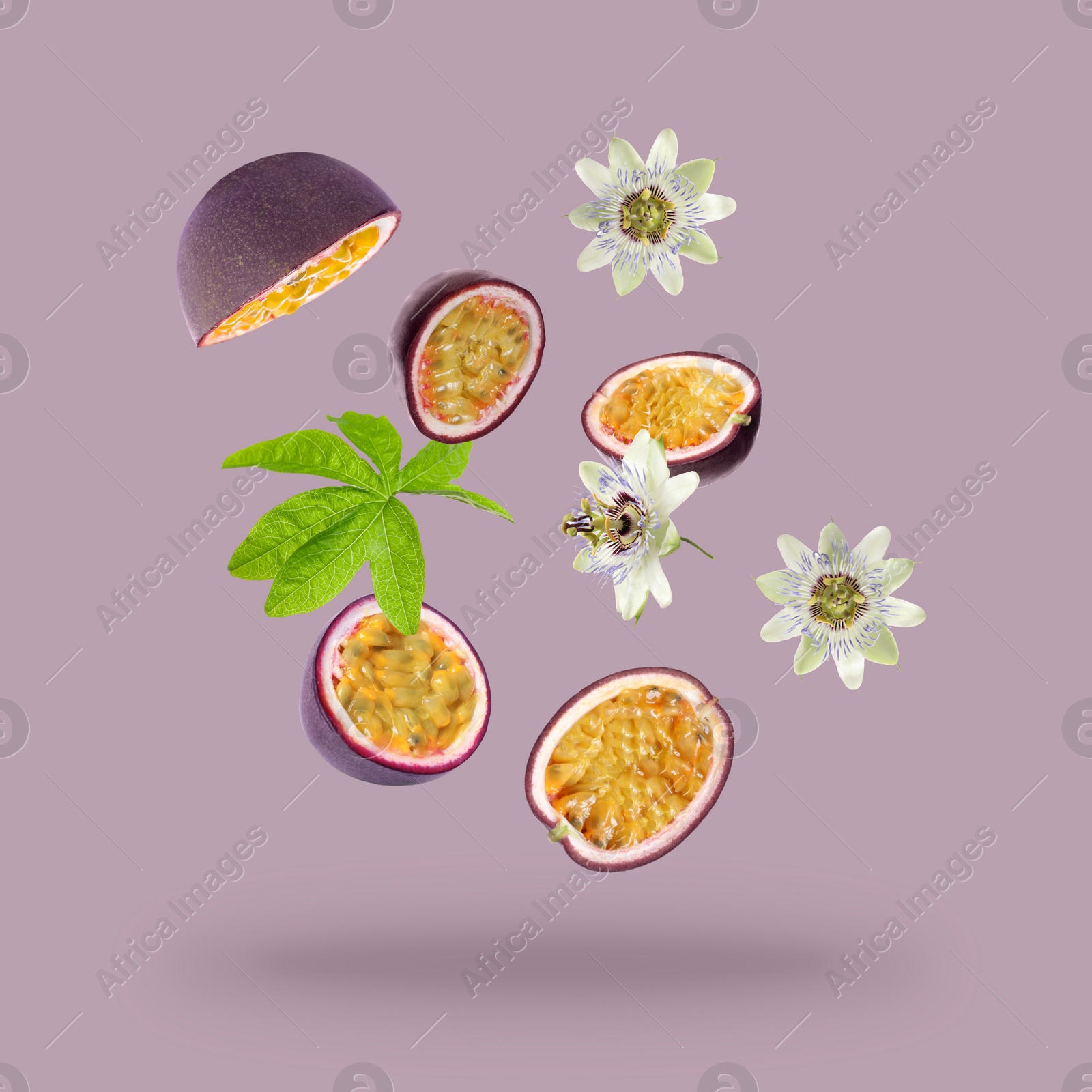 Image of Tasty passion fruits, passiflora leaf and flowers falling on pink background