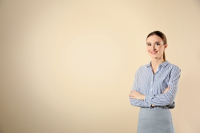 Portrait of young female teacher on beige background. Space for text