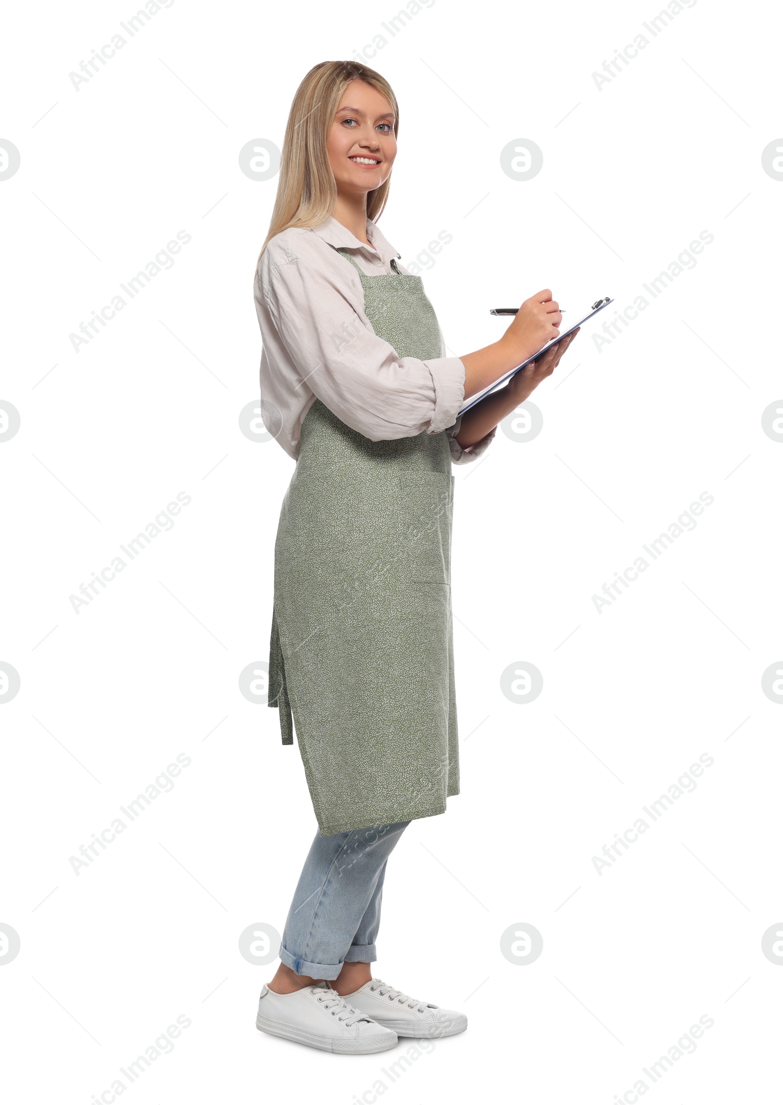 Photo of Beautiful young woman in clean apron with clipboard on white background