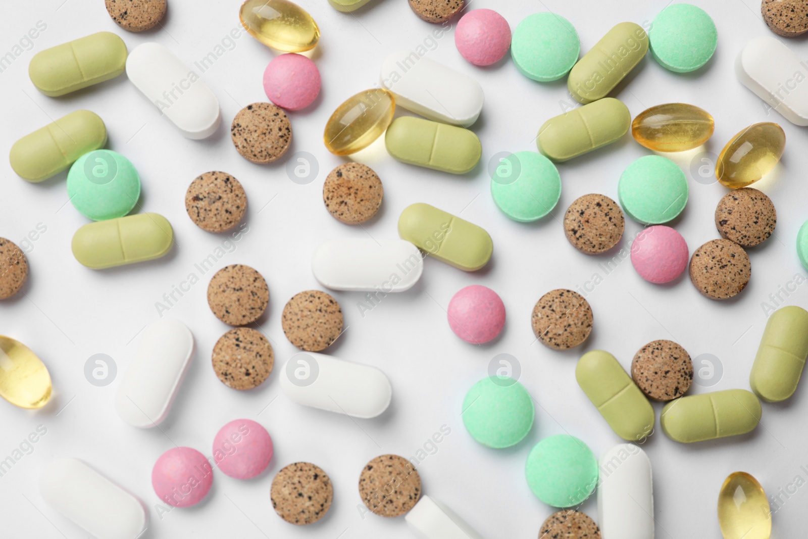 Photo of Different vitamin pills on white background, flat lay