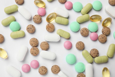 Photo of Different vitamin pills on white background, flat lay