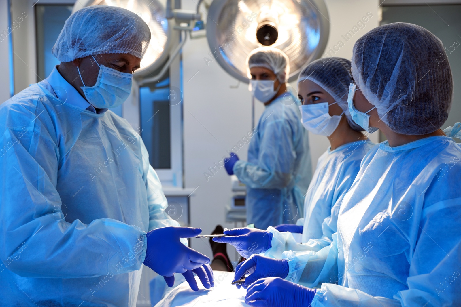 Photo of Team of professional surgeons performing operation in clinic