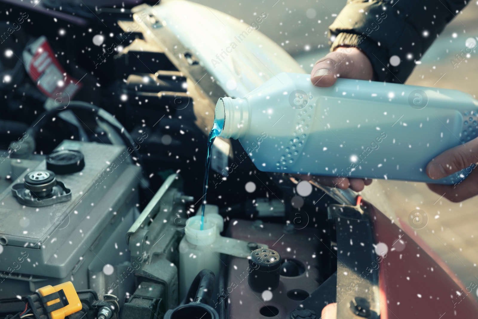 Image of Man filling car radiator with antifreeze outdoors, closeup