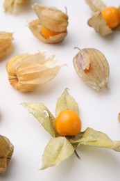 Ripe physalis fruits with calyxes on white background, closeup